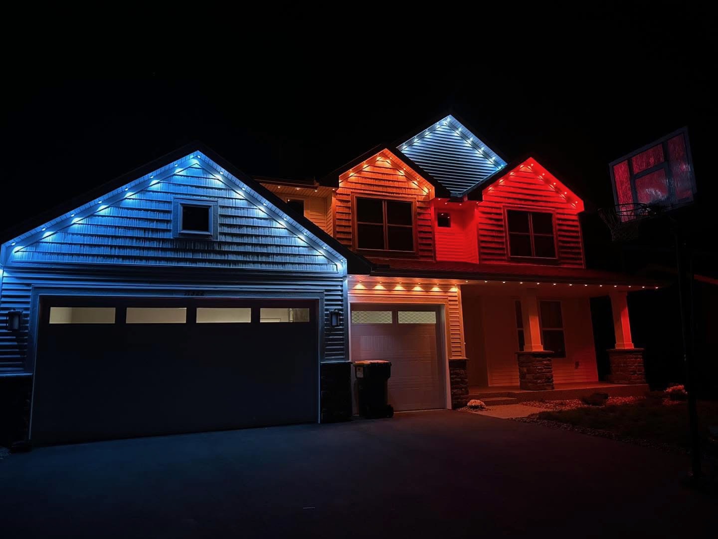 Bright white LED lighting along the eaves and gables of a two-story home at night